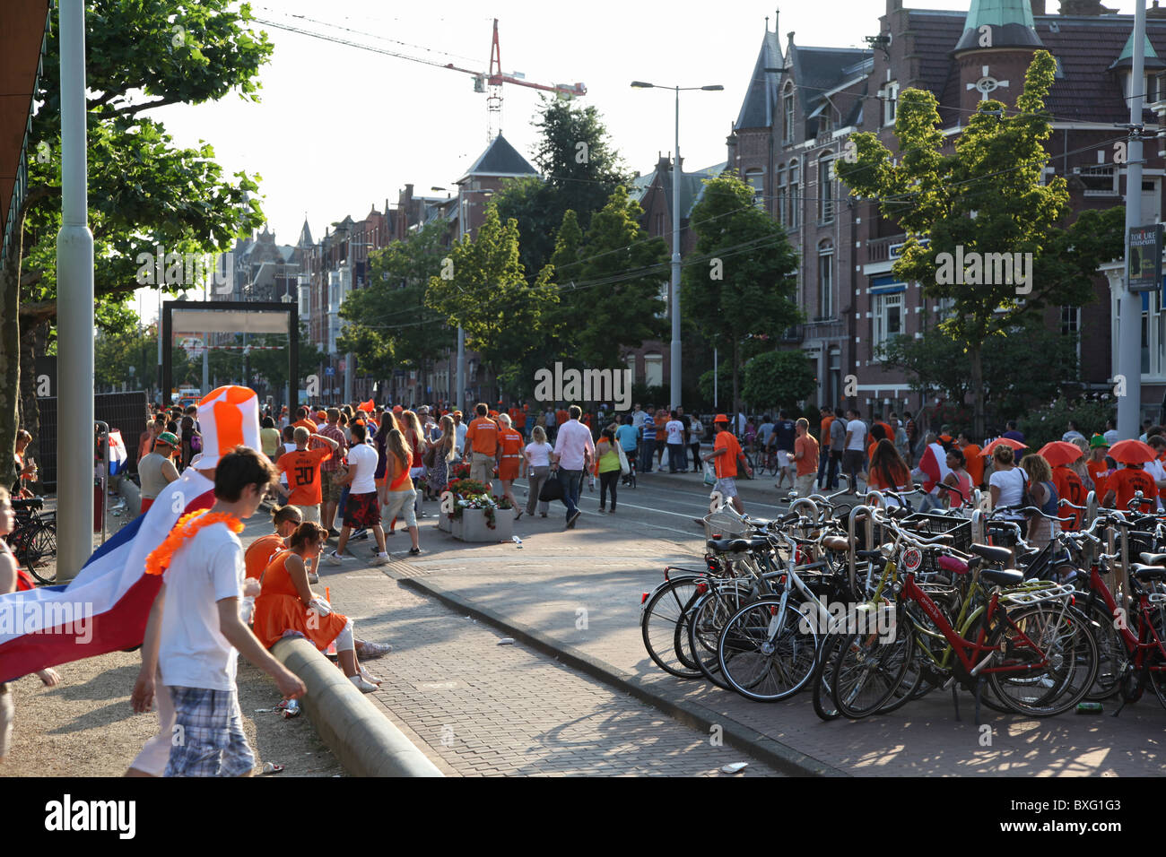 Fußballfans gehen zum Museumplein, Amsterdam, in Erwartung des WM-Finales zwischen den Niederlanden und Spanien 2010 Stockfoto