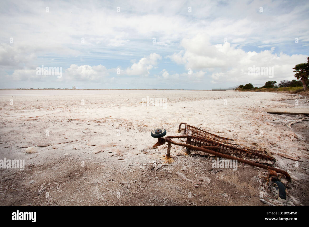 Verrosteten Einkaufswagen im Sand begraben Stockfoto