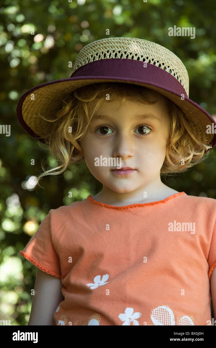 Kleines Mädchen trägt einen Strohhut Stockfoto