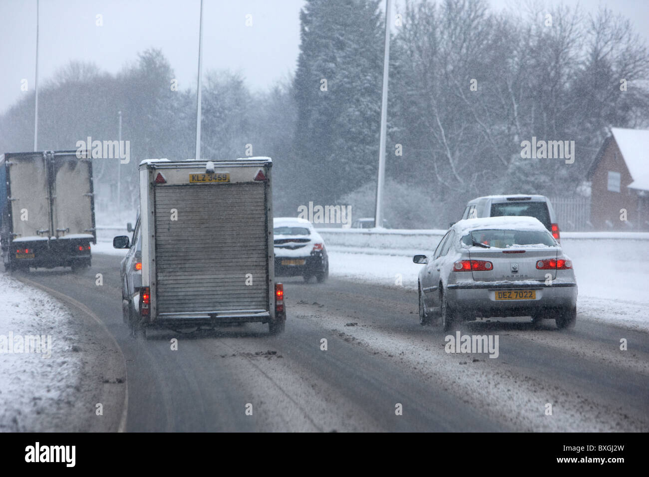 Auto Transporter und Anhänger auf einer zusammengebissenen Autobahn an einem kalten verschneiten Winter Tag Belfast Nordirland Stockfoto