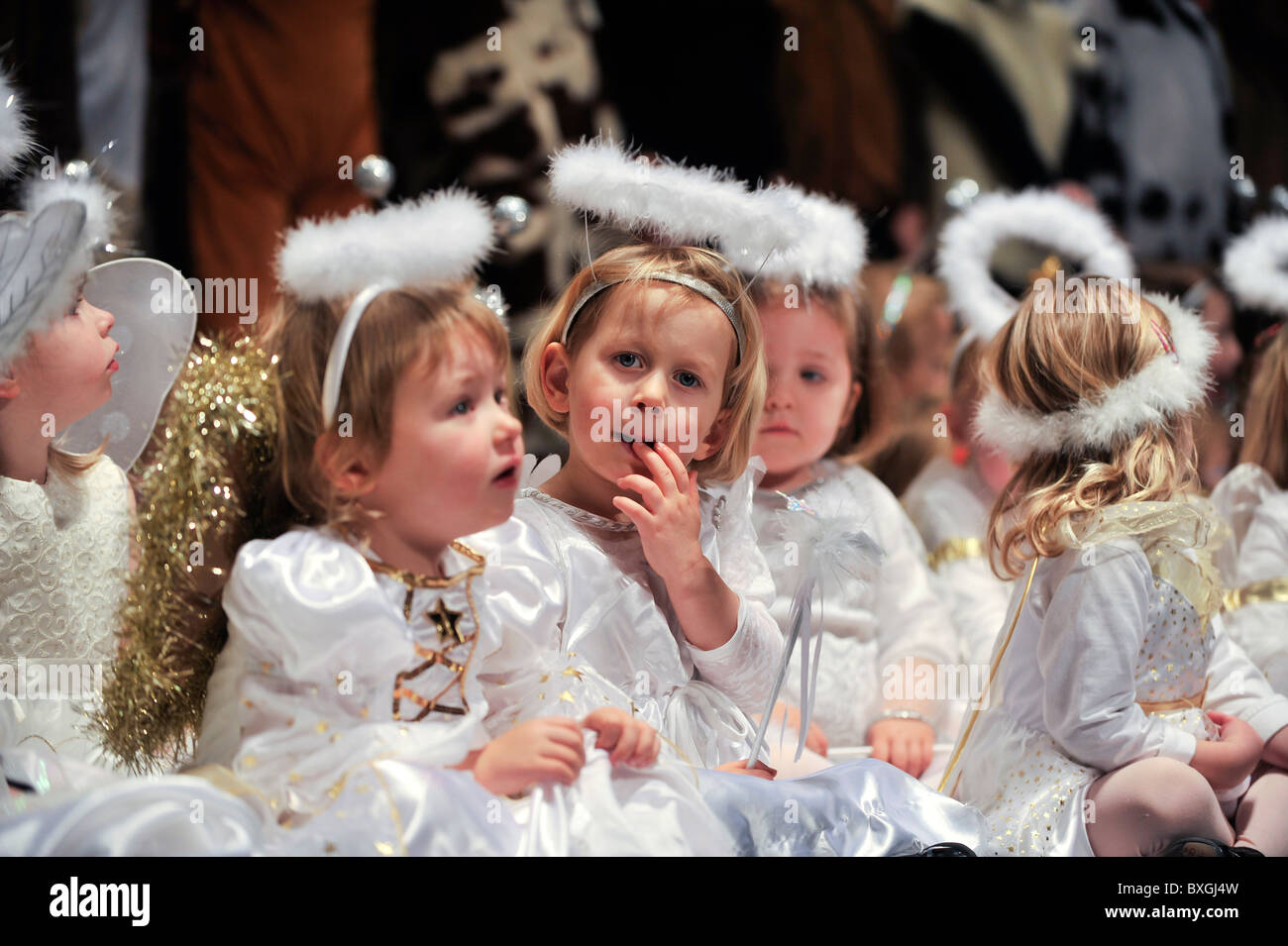 Kinder, verkleidet als Engel, die Durchführung in einer Grundschule Weihnachten Krippe spielen, UK Stockfoto