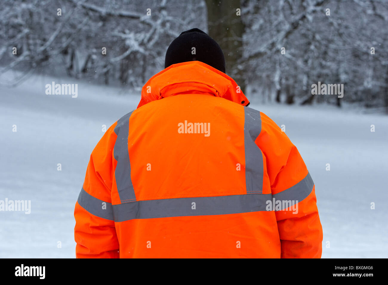 Mann trägt Hivis orange Jacke an einem kalten verschneiten Wintertag Belfast Nordirland Stockfoto