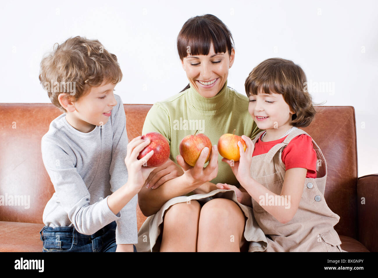 Mutter und Kinder halten Äpfel Stockfoto