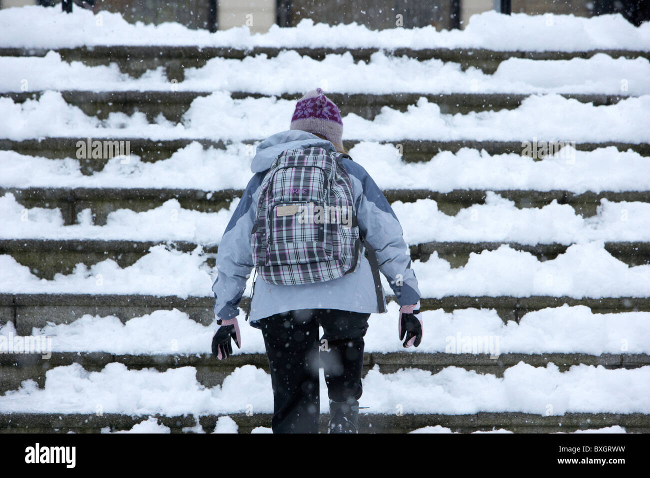 junge Frau zu Fuß Schritte an einem kalten verschneiten Winter Tag Belfast Nordirland Stockfoto