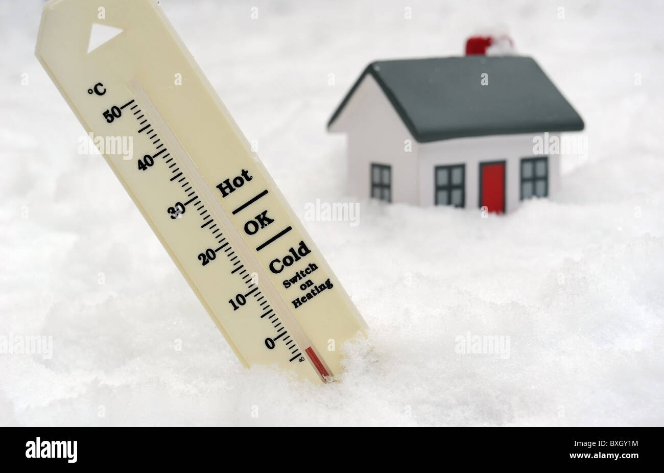 THERMOMETER IM WINTERSCHNEE ZEIGT MINUS TEMPERATUR MIT EINSCHALTEN DER HEIZUNG ZEICHEN UND HAUS UK Stockfoto