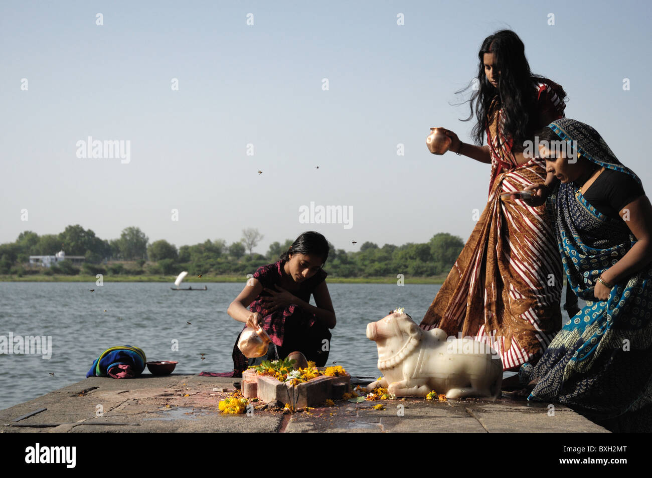 Drei indische Frauen führen einen Segen in Maheshwar, Indien. Stockfoto