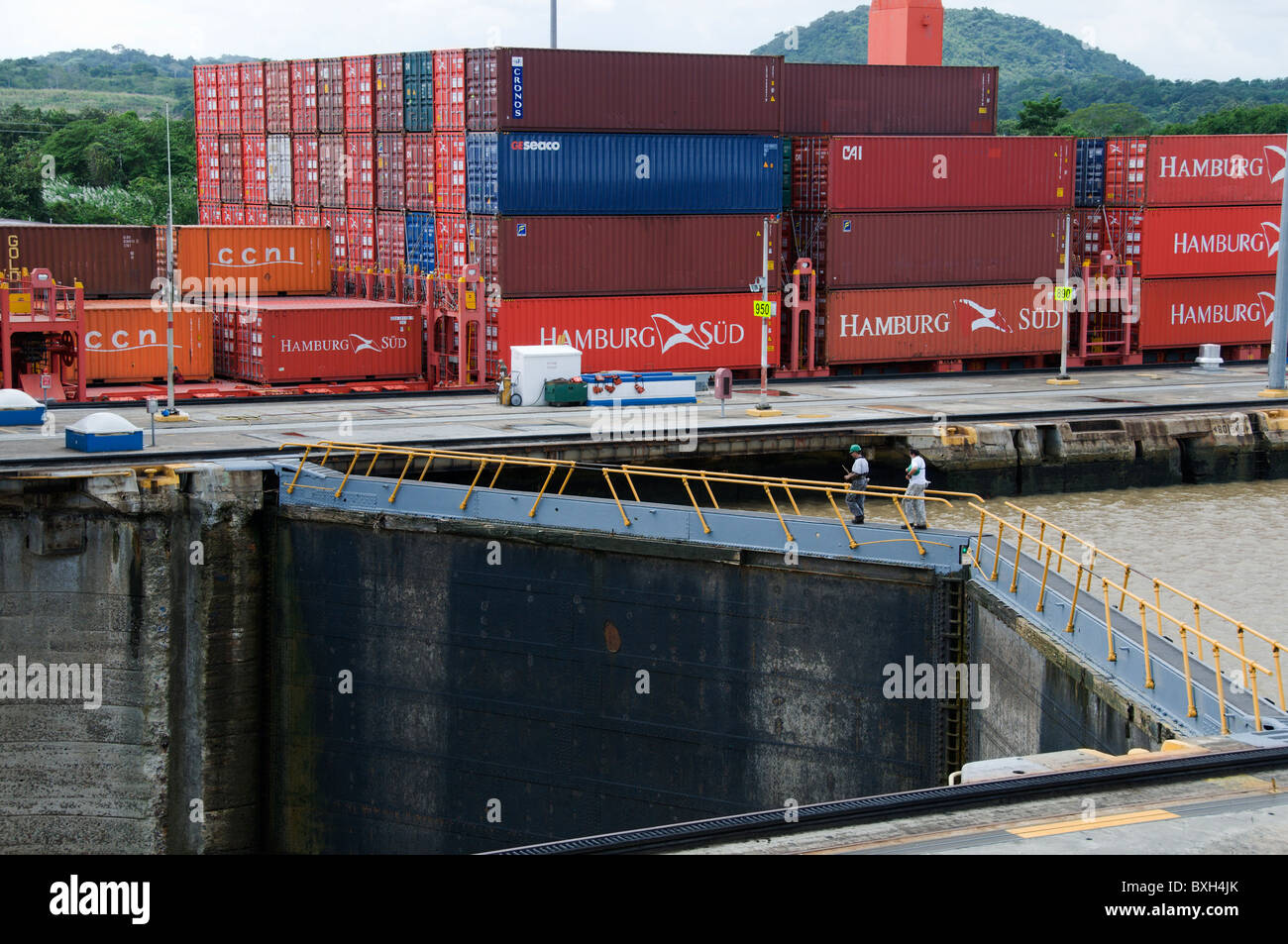 Gefüllt mit Containern voll beladenen Frachtschiff bewegt sich durch die Miraflores-Schleusen des Panama-Kanals. Stockfoto