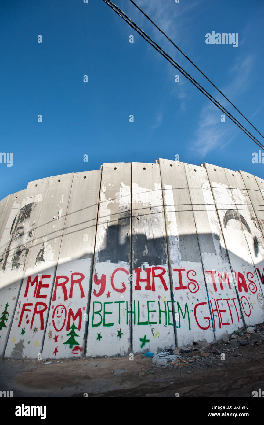 Graffiti auf die israelischen Trennmauer in der Westbank-Stadt Bethlehem liest, "Merry Christmas from Bethlehem Ghetto." Stockfoto