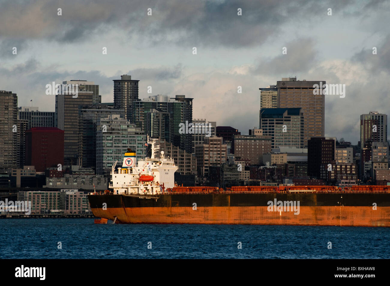 Ein Containerschiff reiht sich Container im Hafen von Seattle Terminal entlang des Duamish Flusses mit der Skyline von Seattle zu laden. Stockfoto
