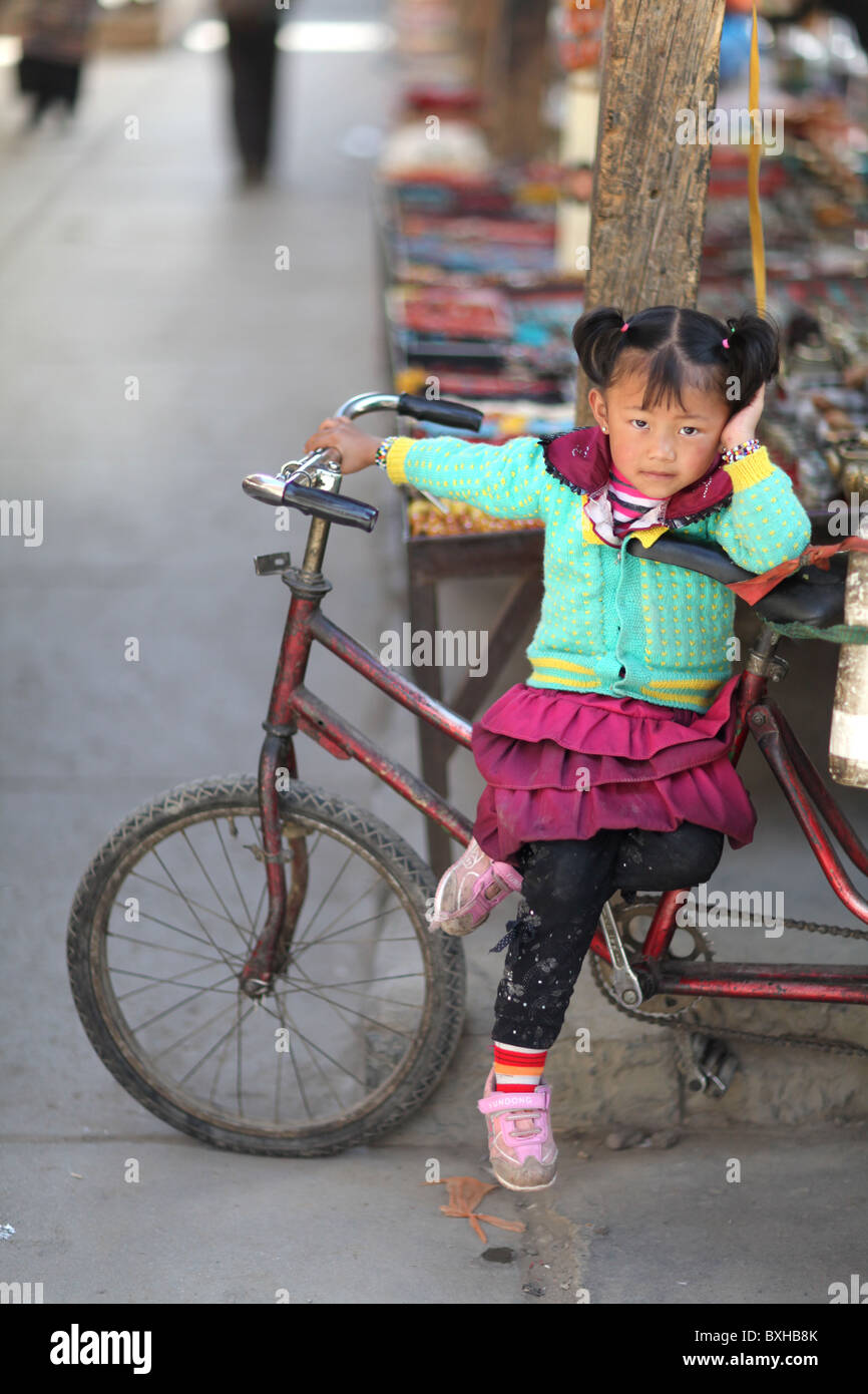 Ein junges Mädchen ruht auf einem Fahrrad in Shigatse oder Xigazê, Tibet, tibetische Antomonous Region von China. Stockfoto