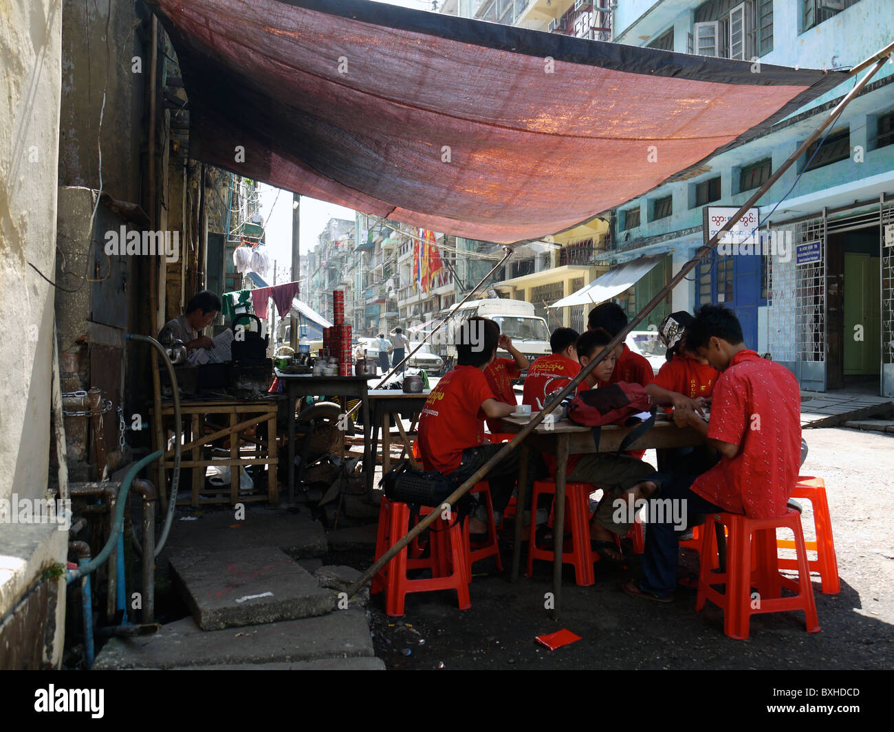 Männer in roten T-shirts, Essen in einem Straßencafé, Yangon Burma Myanmar Stockfoto