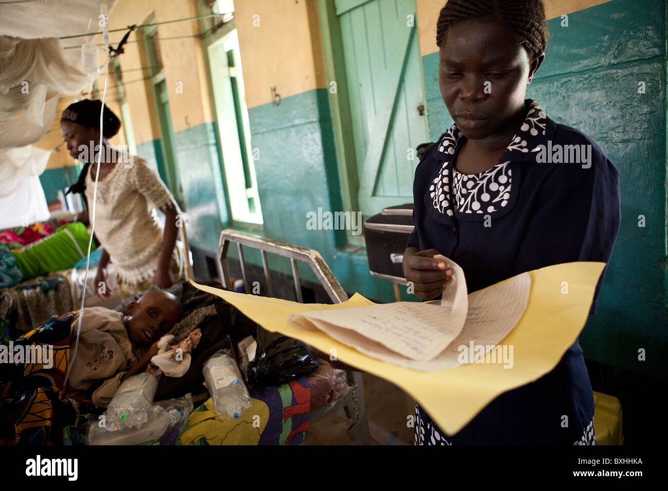 Ein Arzt sieht über die Aufzeichnungen eines Kindes in einem Hosptial in Amuria, Uganda, Ostafrika an AIDS sterben. Stockfoto
