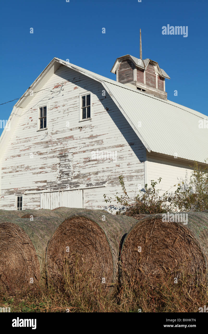 Weiße Scheune mit Strohballen in Iowa. Stockfoto
