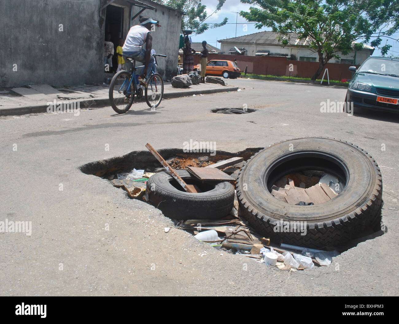 Riesige Schlaglöcher in einer Straße in Abidjan, Elfenbeinküste Stockfoto