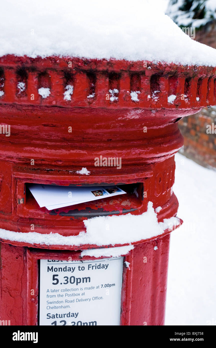 Posten Briefe / Weihnachtskarten in einen roten Briefkasten mit Schnee bedeckt. UK Stockfoto