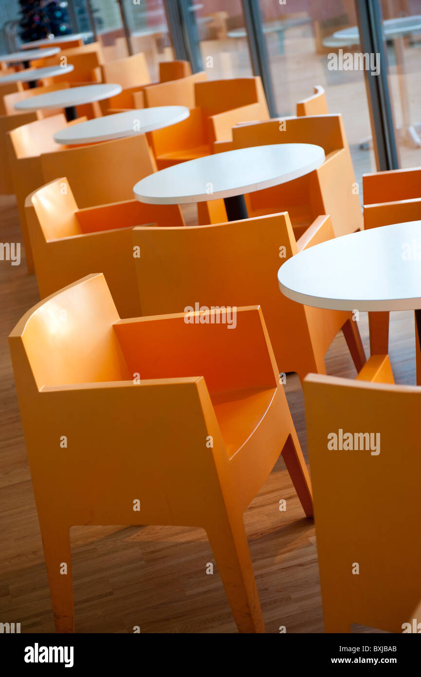 Orangefarbene Stühle aus Kunststoff Polypropylen Philippe Starck "Spielzeug" in einem café Stockfoto