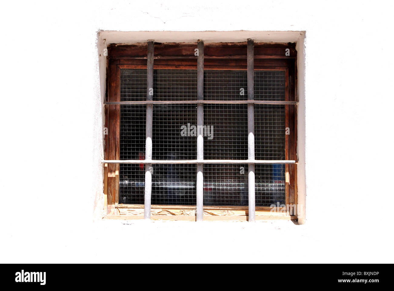 Fenster mit Sicherheit Eisenstangen in der Wand aus weißen Steinen und Zement Stockfoto