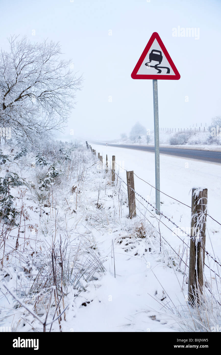 Winterdienst mit dem Einfrieren, Nebel, Schnee und Warnzeichen in der Nähe von Floak auf der Straße zwischen Kilmarnock und Glasgow, Schottland Stockfoto