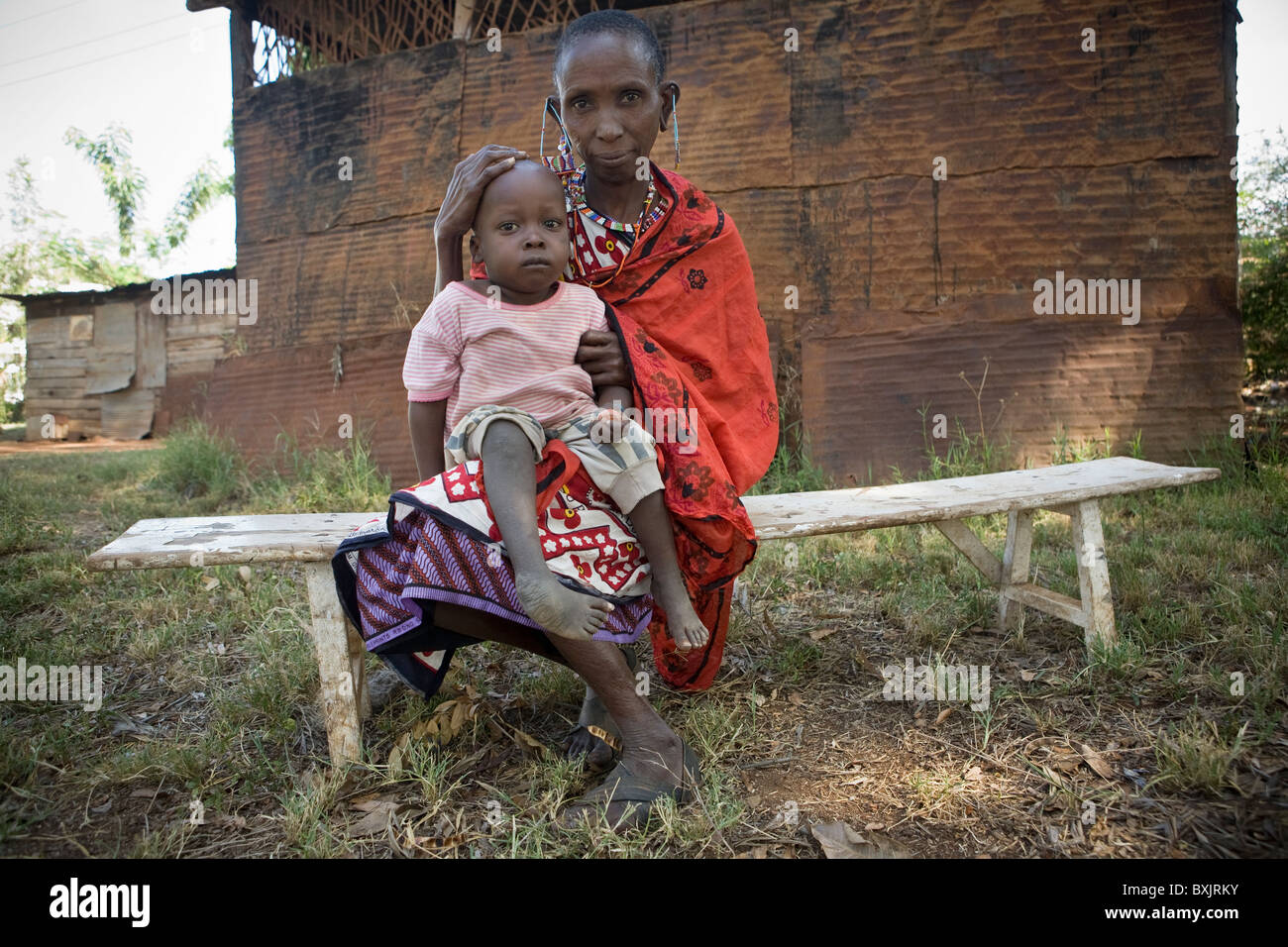 Porträt einer Massai-Frau mit ihrem Enkel, der mit einem Klumpfuß - Tansania, Ostafrika leidet. Stockfoto