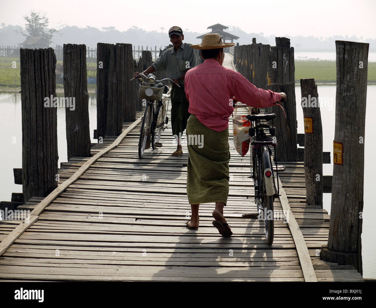 Männer zu Fuß entlang U Bein Brücke, weltweit längste Teakholz span Fußgängerbrücke über den Taungthaman-See, Amarapura Stockfoto