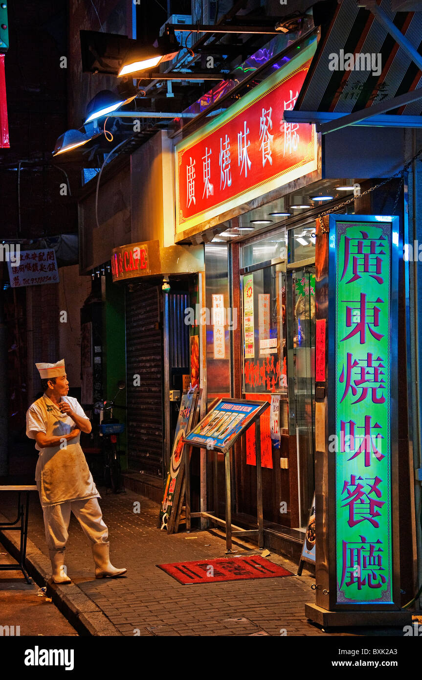 Asiatischen männlichen Küche Arbeiter stehen außerhalb Restaurants Rauchen einer Zigarette in der Innenstadt von Hongkong China Stockfoto