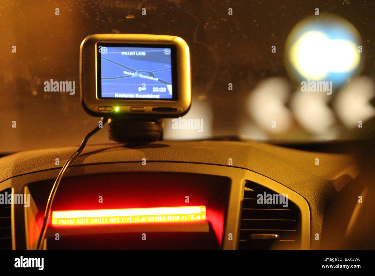 Navi-Gerät thront auf dem Armaturenbrett eines Autos in der Nacht Stockfoto