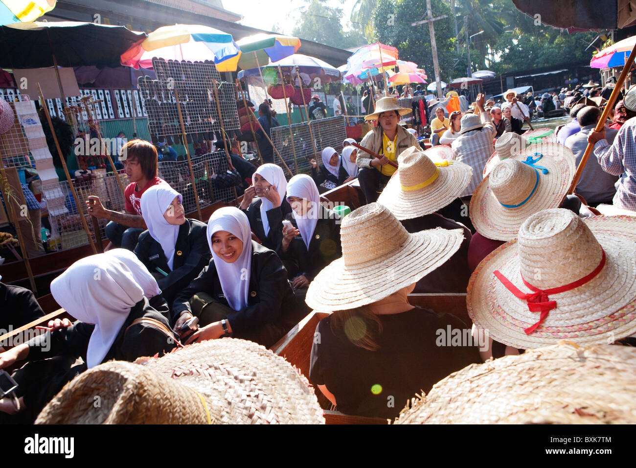 Touristen in traditionellen Strohhüte, Reiten durch die Damnoen Saduak floating Market in ein Touristenboot Stockfoto