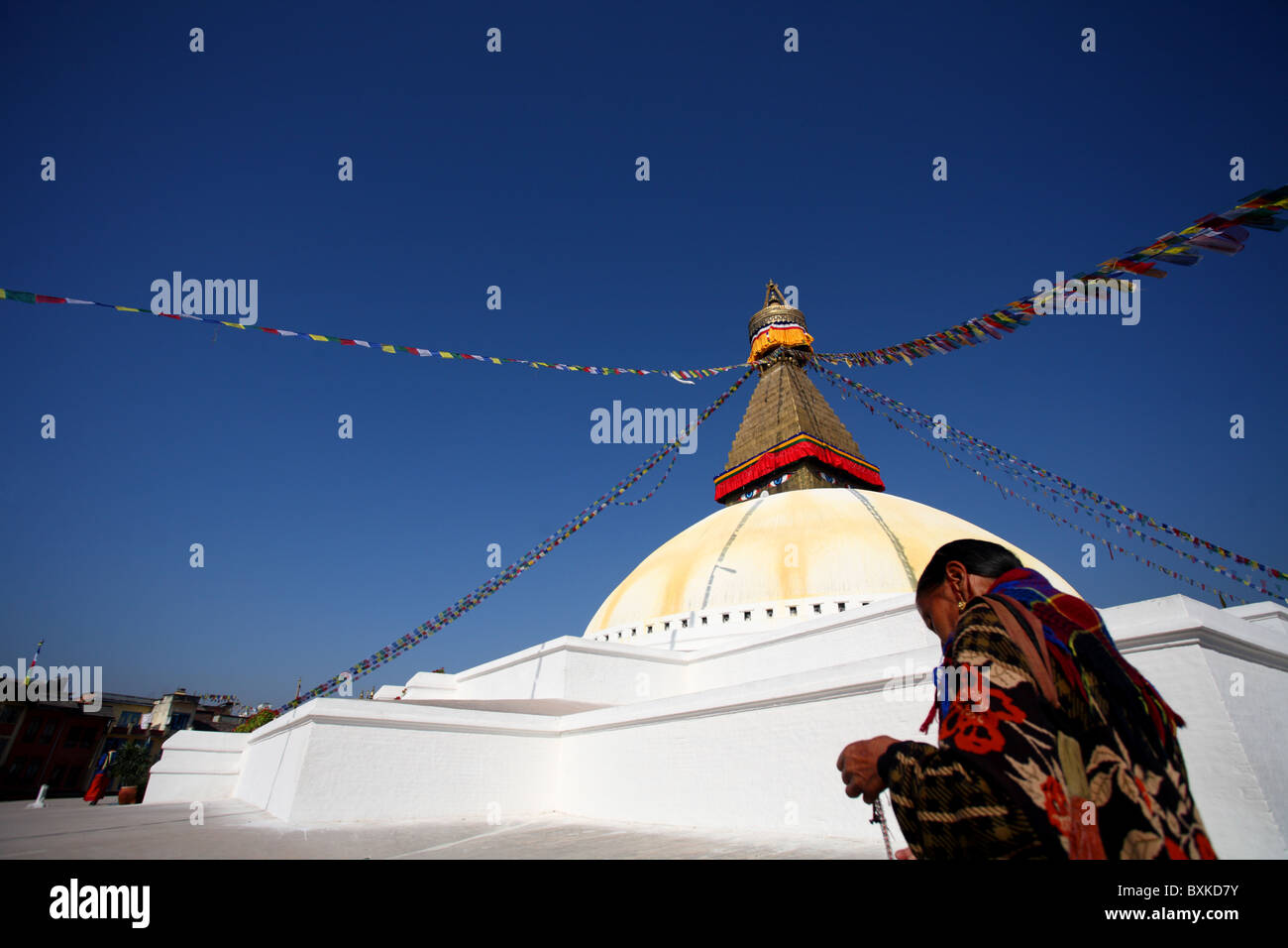 Eine tibetische Frau kreist die Bodnath Stupa in Kathmandu, Nepal. Stockfoto