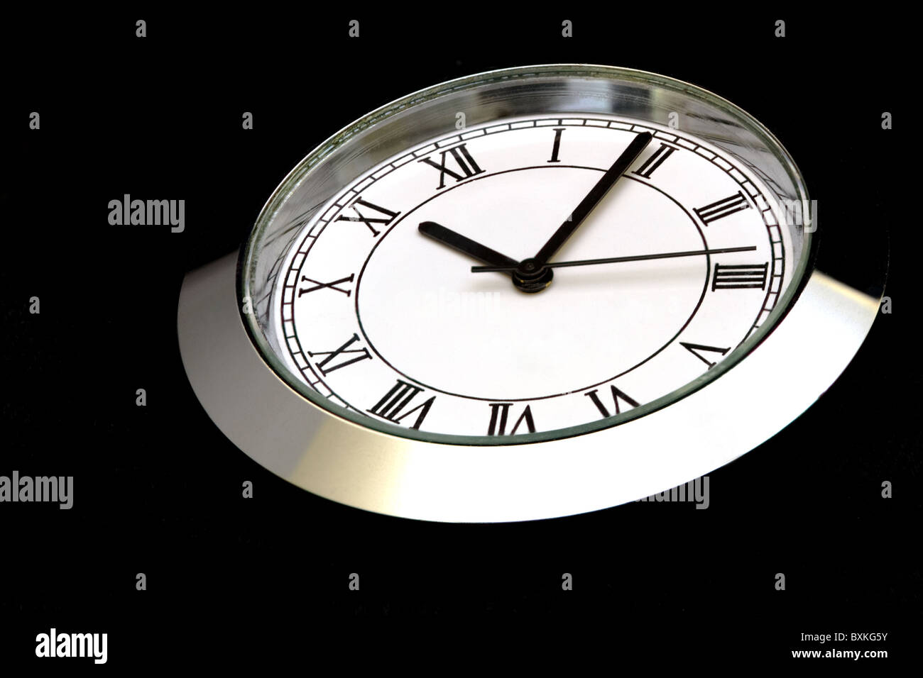Extreme Nahaufnahme von Stahluhr mit römischen Ziffern auf schwarz Stockfoto