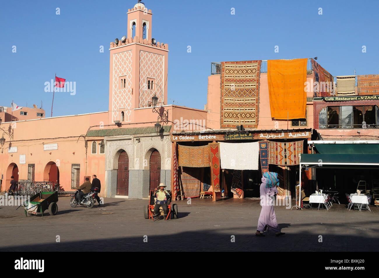Minarett der Moschee und inzwischen an beschäftigt Djemaa el-Fna Treffpunkt in Marrakesch Stockfoto
