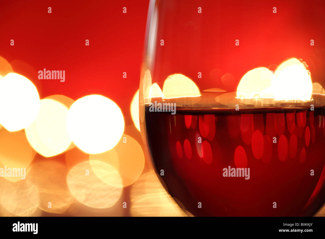 Glas Rotwein gegen defokussierten Lichter Stockfoto