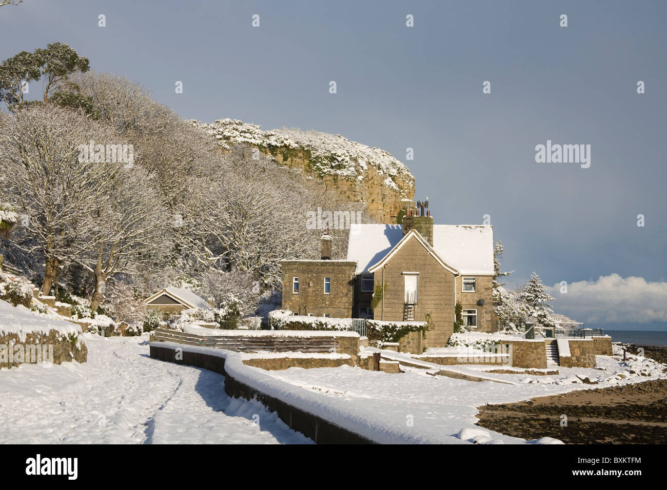 Isle of Anglesey Wales Dezember Blick entlang am Meer zu Castle Rock an einem Wintertag nach einem außergewöhnlich starken Schneefall Stockfoto