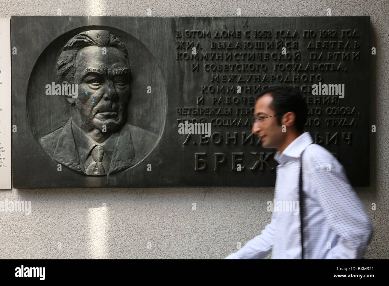 Mann, vorbei an einer Gedenktafel aus dem Hause Leonid Brezhnev in Moskau im Mauermuseum in Berlin, Deutschland. Stockfoto