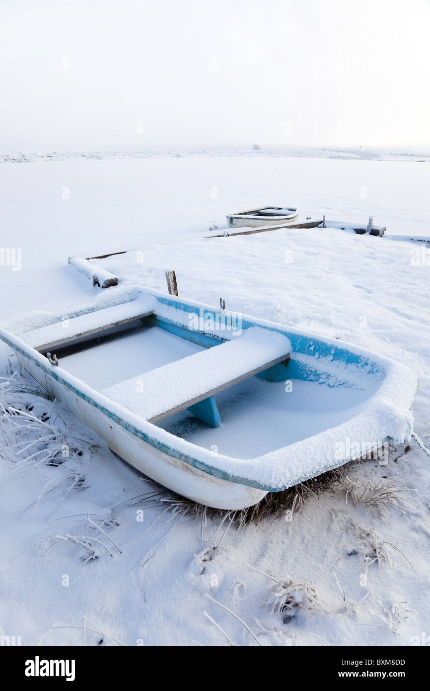 Zwei Boote gefesselt an einem Pier auf ein kleines Loch und die Boote, bedeckt mit Schnee und Frost, Eaglesham Moor, in der Nähe von Glasgow Stockfoto