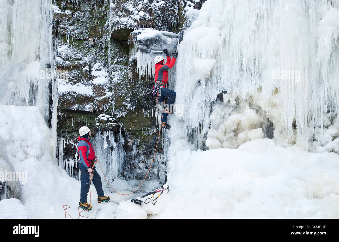 Zwei Männer auf einem Eis klettern auf einem gefrorenen Wasserfall (Lynn fällt) außerhalb Dalry in North Ayrshire, Schottland, Vereinigtes Königreich. Stockfoto