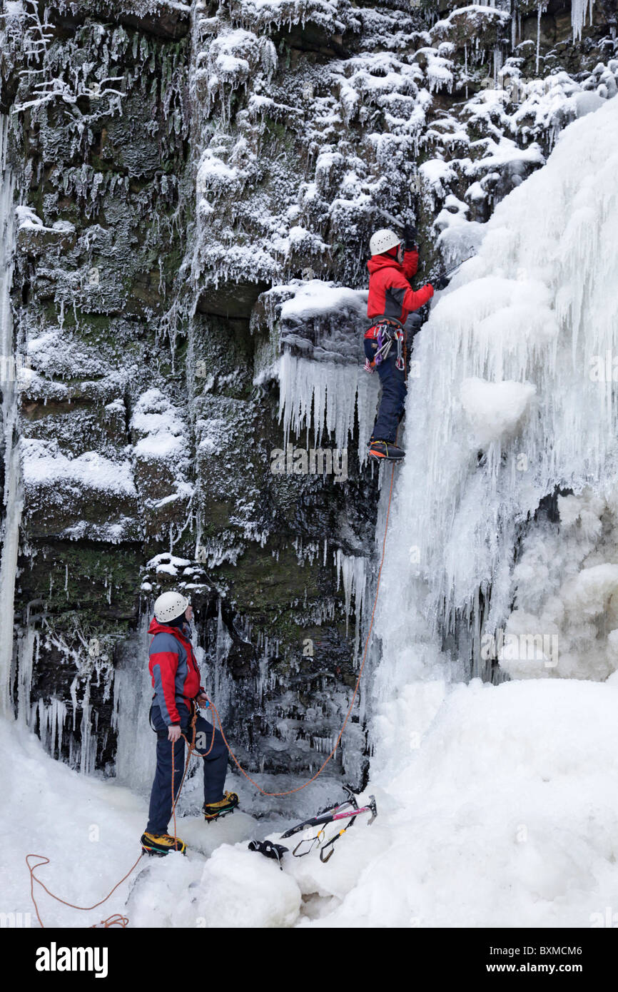 Zwei Männer auf einem Eis klettern auf einem gefrorenen Wasserfall (Lynn fällt) außerhalb Dalry in North Ayrshire, Schottland, Großbritannien. Stockfoto
