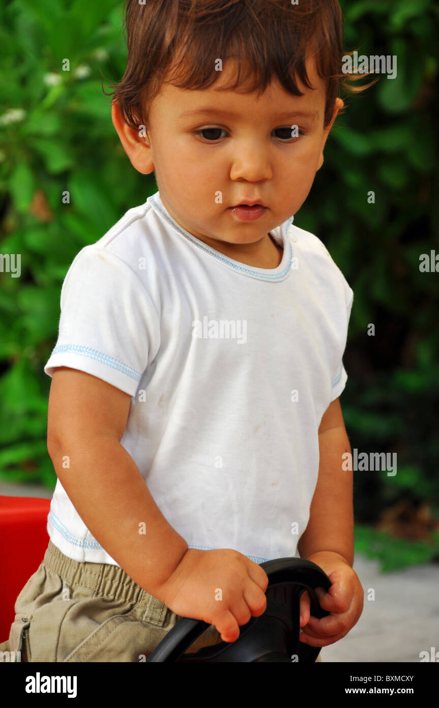 Porträt von einem 1 Jahr alten Jungen in Spielzeugauto Stockfoto