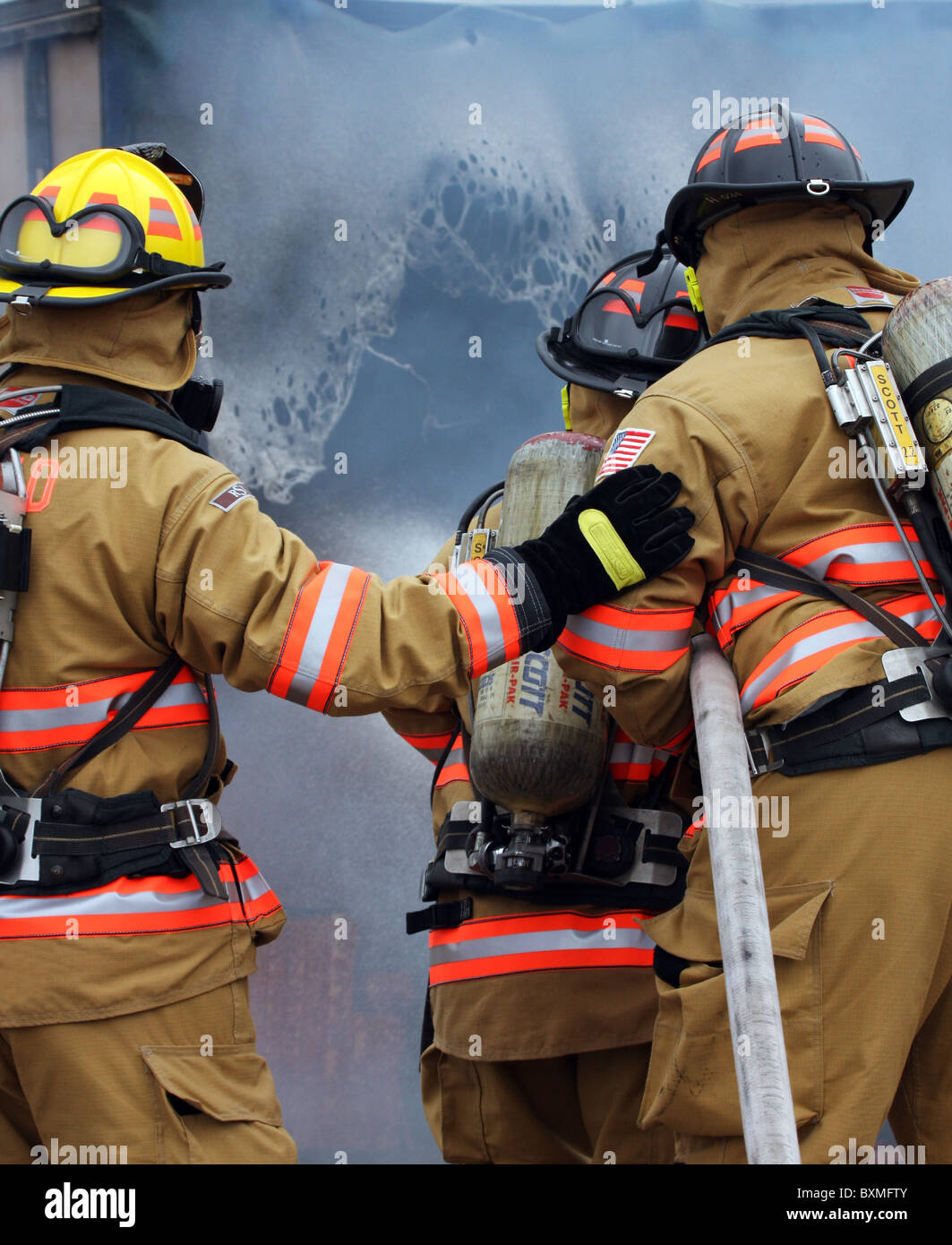 Feuer-Kämpfer, ein Feuer mit schmelzender Kunststoff in einem Raum setzen Stockfoto