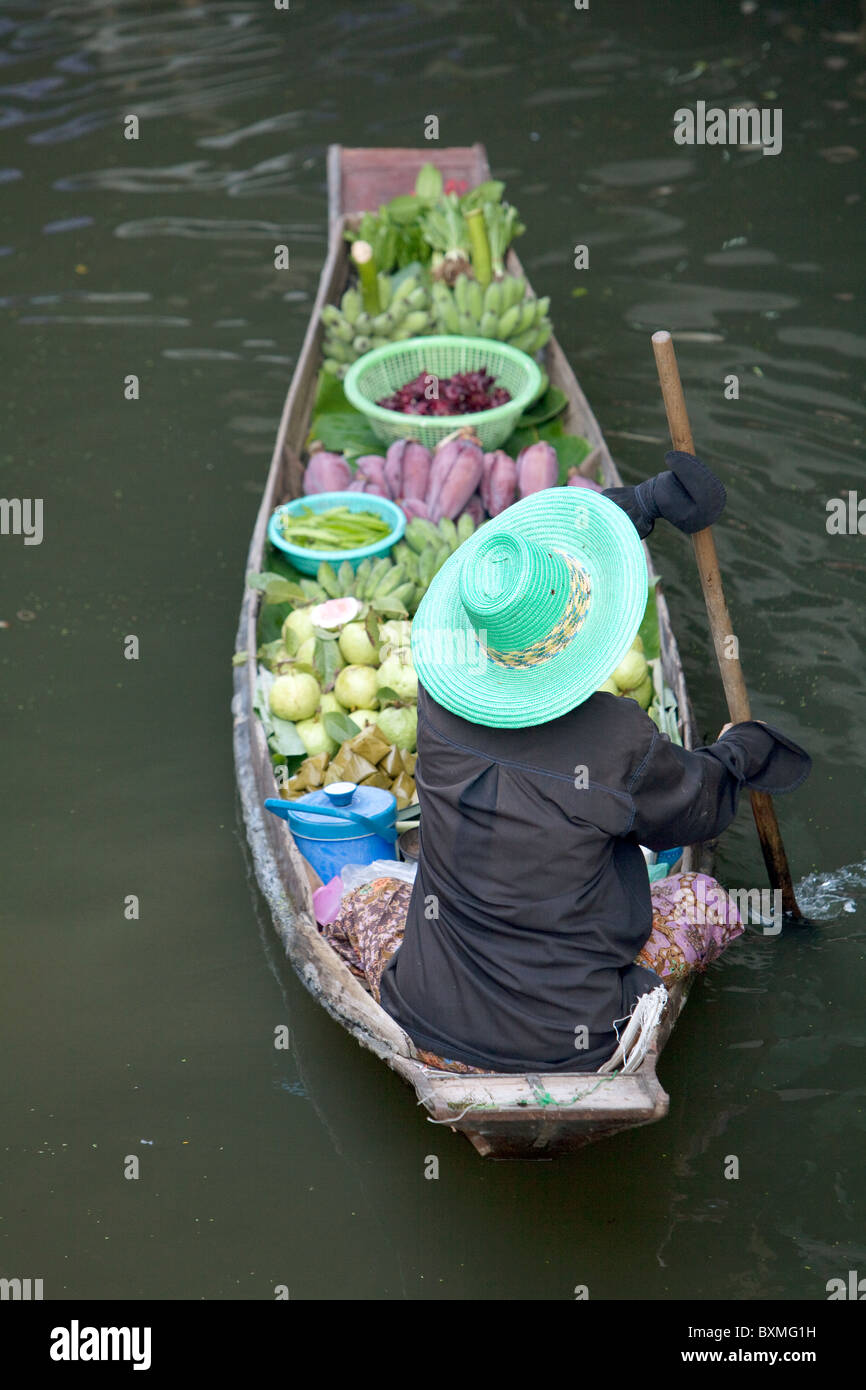 Thai Frau paddeln durch die Kanäle in einem langen Boot voll mit Gemüse Stockfoto