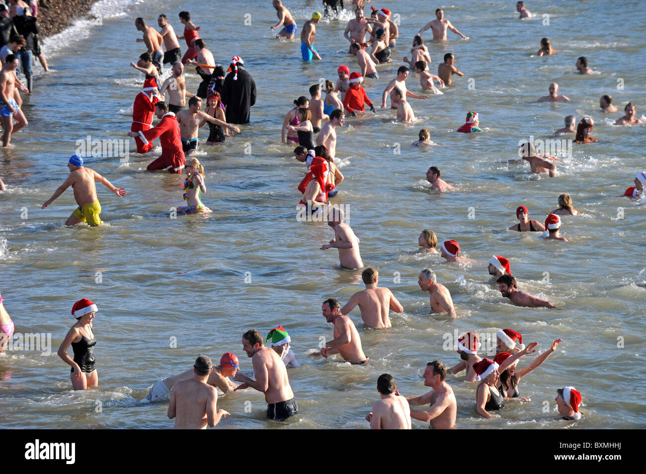 Hunderte von Menschen versammeln sich auf Brighton Beach zu beobachten und Teilnahme an der jährlichen Christmas Day schwimmen Stockfoto