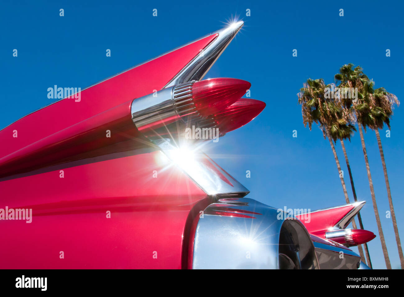 Oldtimer Automobil Flossen und Rückleuchten glänzen in der California Sun. Mit Palmen im Hintergrund. Stockfoto