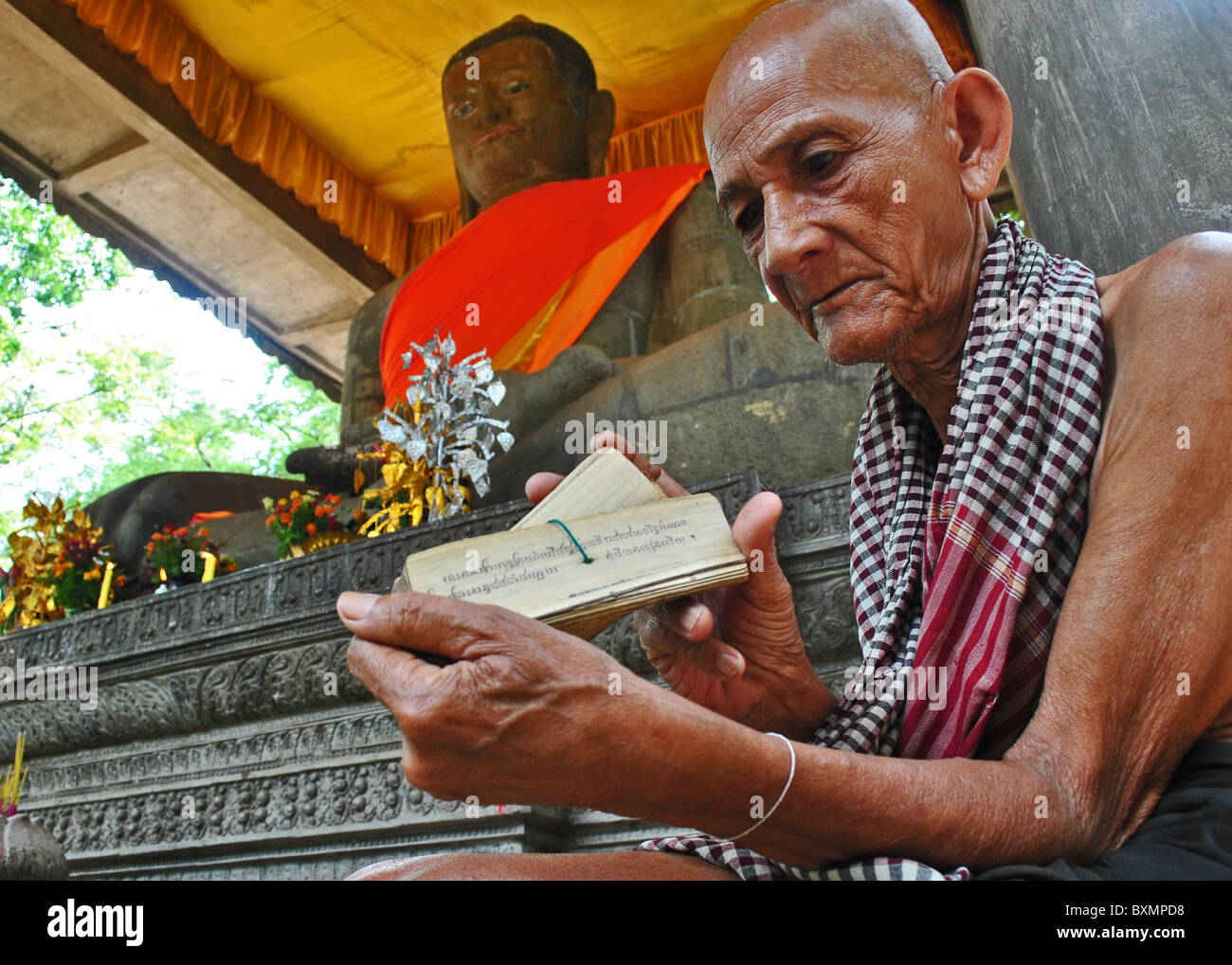 Alte buddhistische Mönch Lesung Skripts in einem Tempel in der Nähe von Angkor Thom, Kambodscha Stockfoto