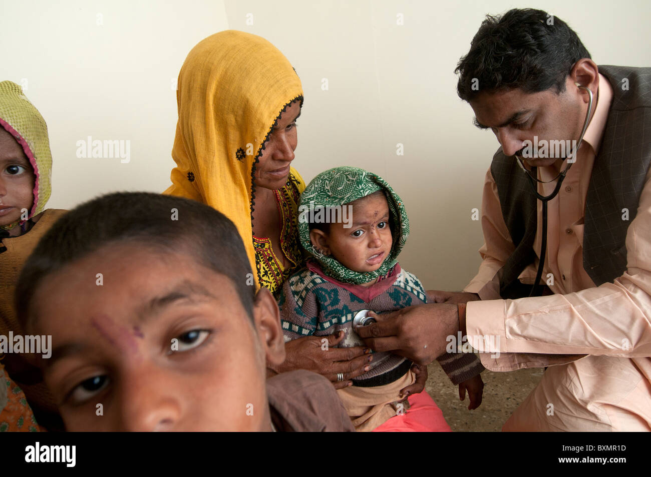 Pakistan nach der Flut. Männlichen Arzt untersucht ein baby Stockfoto