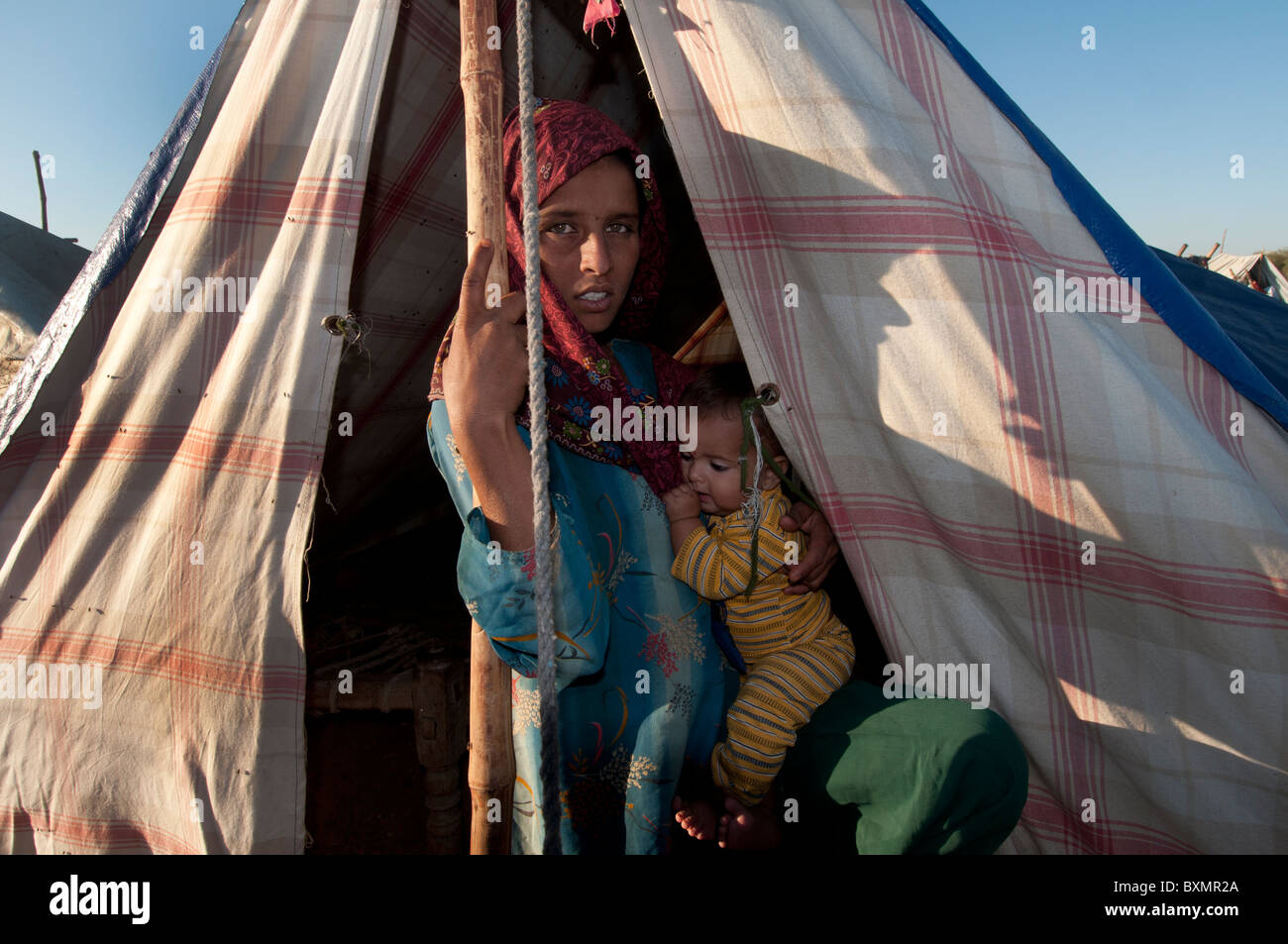 Pakistan nach der Flut. Ameerazadi Beroyi hält Gul Khatoun, 7 Monate alt. Tankstelle-Camp. Stockfoto