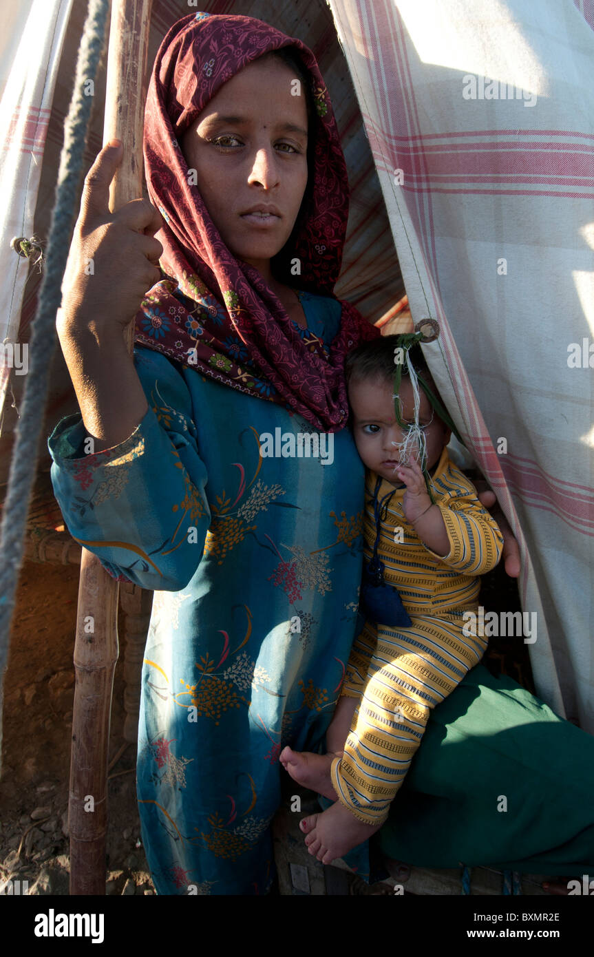 Pakistan nach der Flut. Ameerazadi Beroyi hält Gul Khatoun, 7 Monate alt. Tankstelle-Camp. Stockfoto