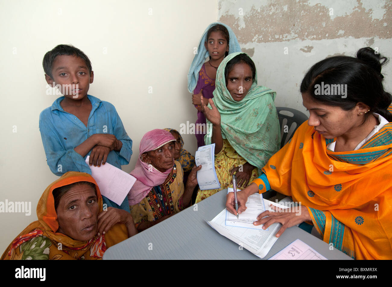 Pakistan nach der Flut. Arzt Sahira Bano untersucht einen Patienten beobachtet von ihrer Familie Stockfoto