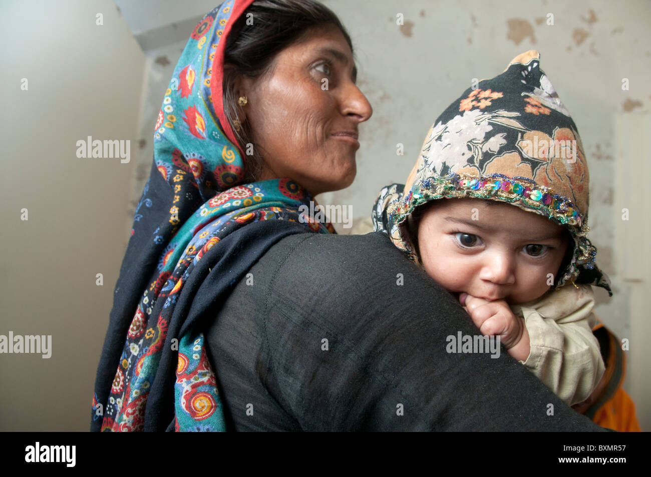 Pakistan Sindh Provinz Shaddat Kot. Nach der Flut. Dezember 2010. Mutter mit Baby warten, einen Arzt aufzusuchen Stockfoto
