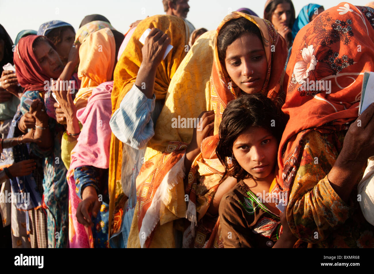 Pakistan. Der Provinz Sindh. Nach der Flut. Lager für Vertriebene. Frauen-Warteschlange, ihre Säcke Weizen zu sammeln Stockfoto