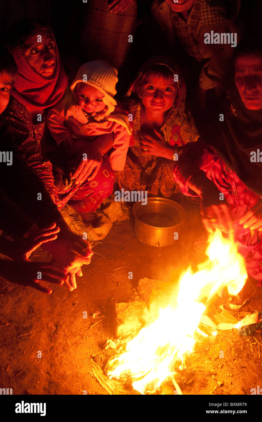 Der Provinz Sindh. Eisenbahn-Lager für Vertriebene. Menschen ohne Zelte wärmen sich durch einen Brand. Stockfoto