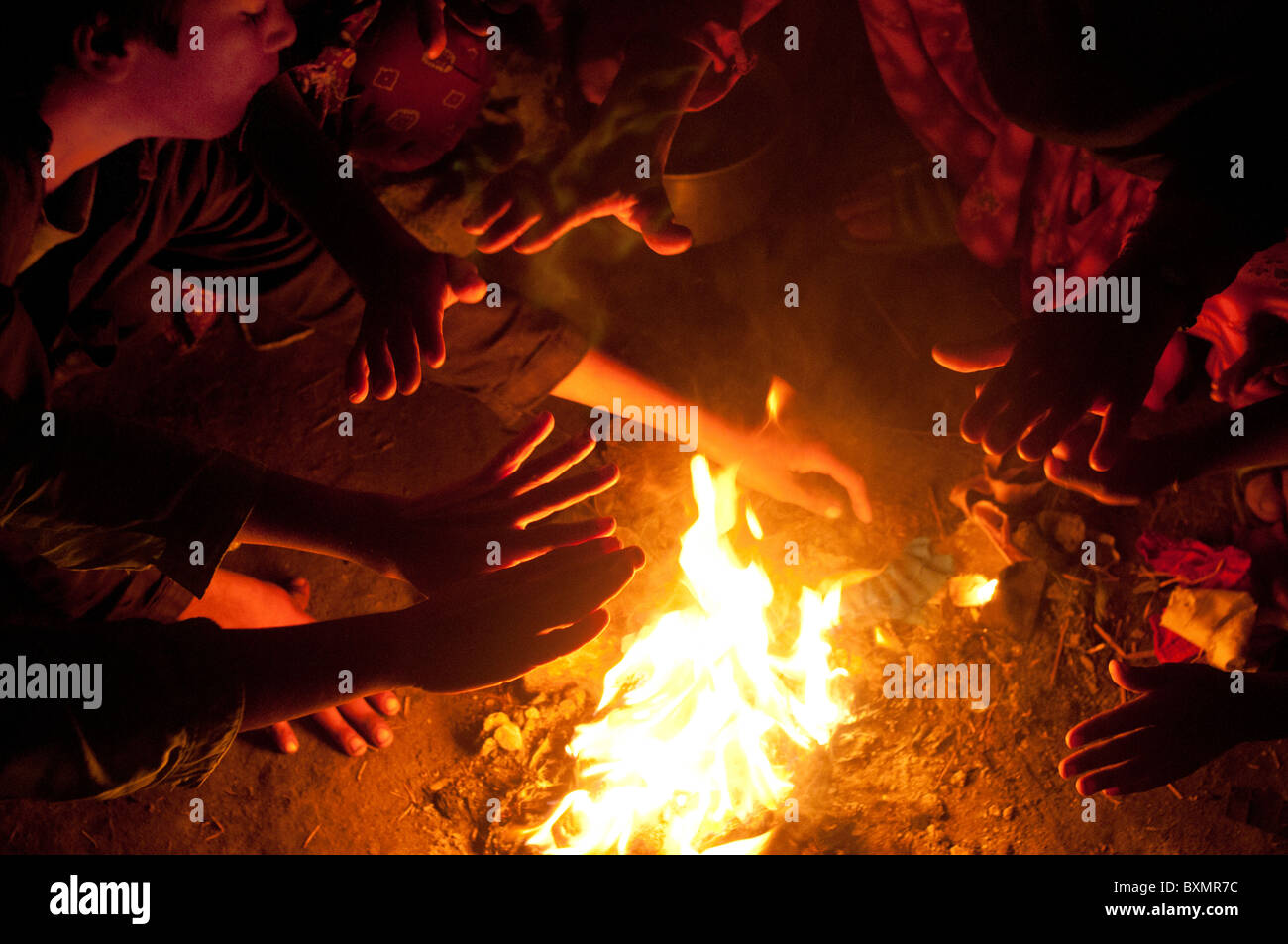 Der Provinz Sindh. Eisenbahn-Lager für Vertriebene. Menschen ohne Zelte wärmen sich durch einen Brand. Stockfoto